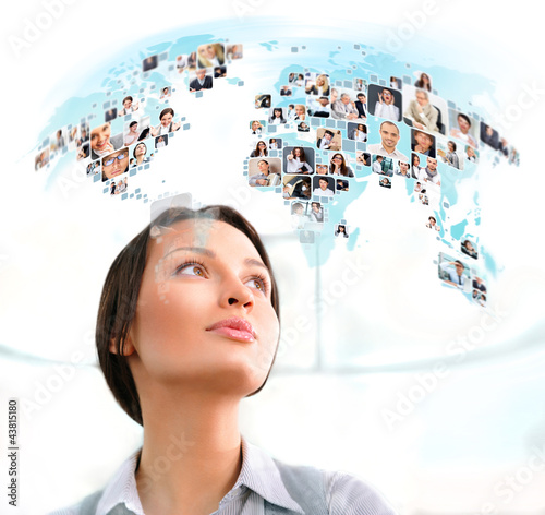 Photo: Young successful woman looking at worldmap with profile photos o Young successful woman looking at worldmap with profile photos o