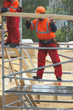 Construction worker is holding a wooden board in rainy day