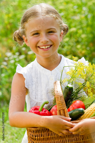 Foto: Vegetable garden - lovely girl with picked vegetables in basket Vegetable garden - lovely girl with picked vegetables in basket