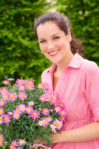 Photo: Female florist hold pink potted flower Female florist hold pink potted flower