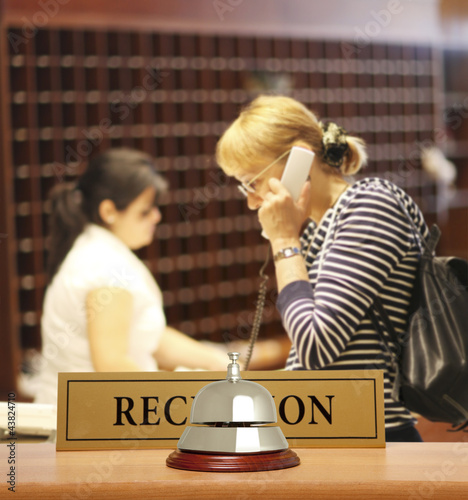 Photo: A woman calling on a hotel reception A woman calling on a hotel reception
