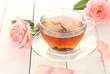 cup of tea with roses on white wooden table
