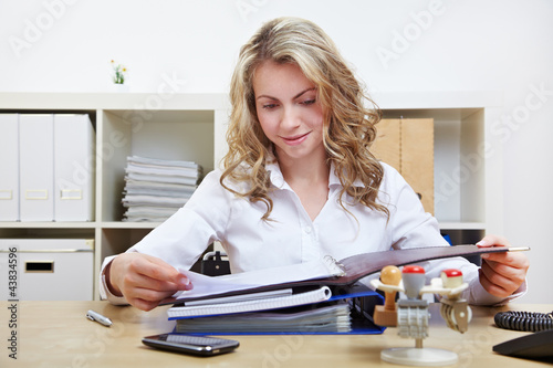 Foto: Personalerin liest Bewerbungsunterlagen im Büro Personalerin liest Bewerbungsunterlagen im Büro