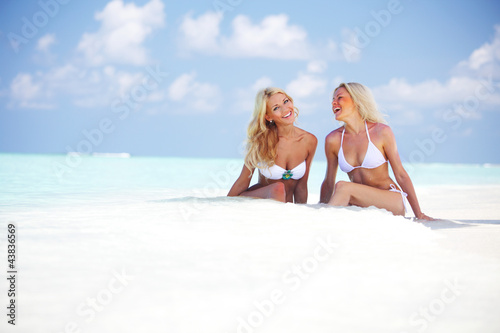 Foto: girls sitting on ocean coast girls sitting on ocean coast