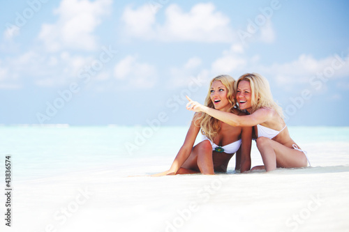 Photo: girls sitting on ocean coast girls sitting on ocean coast