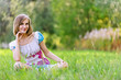 Photo: woman and her little daughter sitting on grass woman and her little daughter sitting on grass