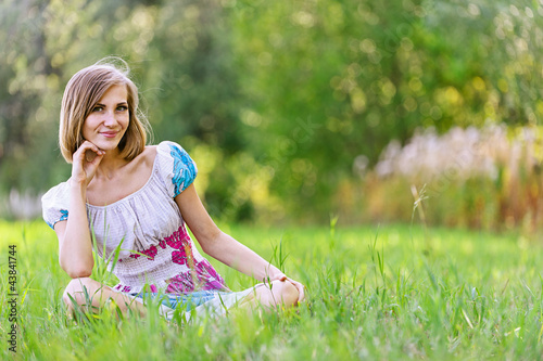 Photo: woman and her little daughter sitting on grass woman and her little daughter sitting on grass