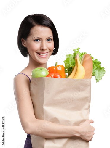 Photo: Attractive girl with the packet of fruit and vegetables Attractive girl with the packet of fruit and vegetables