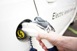 Hand is holding Electric Car Charging nozzle