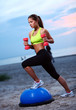 Woman doing fitness exercises with bosu ball