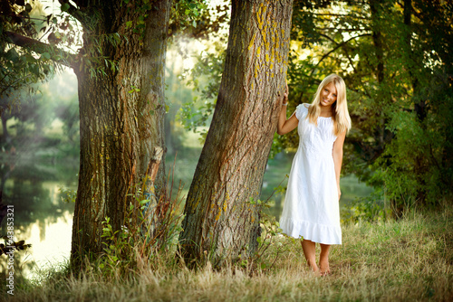 Photo: Beautiful girl in fairy forest near the river Beautiful girl in fairy forest near the river