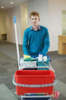 Male cleaner pushing trolley with cleaning equipment