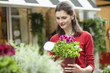 Woman holding a potted plant in a flower shop