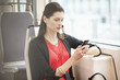 Woman traveling in a bus and using a mobile phone