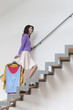 Woman moving up stairs carrying clothes