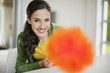 Happy woman holding a feather duster