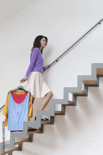 Photo: Woman moving up stairs carrying clothes Woman moving up stairs carrying clothes