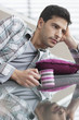 Man reclining on a couch and drinking coffee