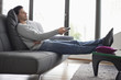 Man reclining on a couch and watching television