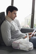 Man sitting on a couch reading medical prescription