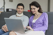 Woman using a laptop with her husband beside her
