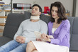 Woman reading a book for her husband suffering from neckache