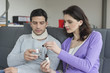 Woman giving medicine to her husband suffering from neckache