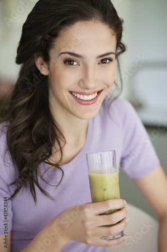 Photo: Woman holding a glass of cold soup and smiling Woman holding a glass of cold soup and smiling