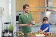 Man and son cutting vegetables in the kitchen
