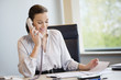 Businesswoman talking on a landline phone in an office