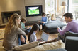 Family using electronic gadgets in a living room