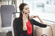 Woman traveling in a bus and talking on a mobile phone
