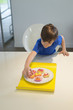 Boy picking a cup cake from plate