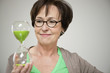 Woman looking at an hourglass and smiling