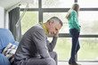 Man looking upset with his daughter standing in the background