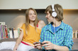 Teenage boy listening to music on iPod with his sister at home