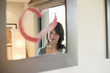 Girl looking at reflection in mirror decorated with heart shape