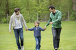 Boy walking with two men in a park