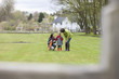 Two women convincing a displeased girl in a park