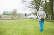 Rear view of a boy hiding a bird's nest behind his back