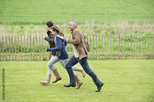 Photo: Happy family running in a field Happy family running in a field