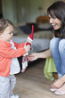 Woman looking at her granddaughter playing with a toy