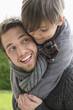 Happy boy riding piggyback on his father
