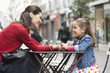 Woman and her daughter sitting at sidewalk cafe