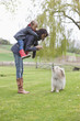 Woman carrying her daughter on piggyback and scolding her dog