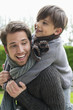 Happy boy riding piggyback on his father