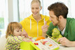 Girl sitting with her parents looking into a knitting kit box