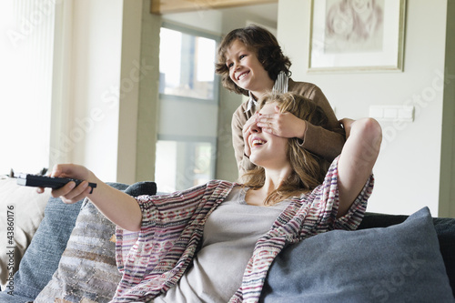 Photo: Boy covering his mother's eyes while watching TV Boy covering his mother's eyes while watching TV