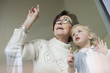 Woman with her granddaughter looking through a window