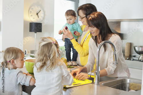 Photo: Girls with her mother and grandmother in a kitchen Girls with her mother and grandmother in a kitchen